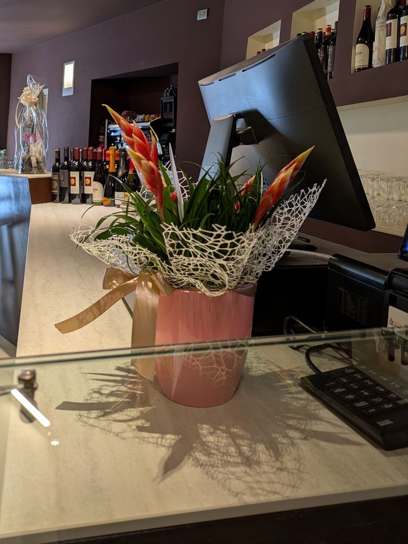 La barra con flores frescas, la caja y los nichos de vinos