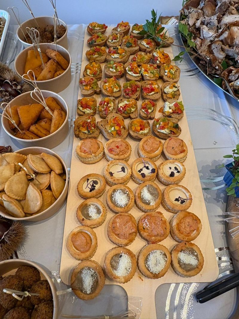 Tartaletas y volovanes rellenos en fila sobre una tabla