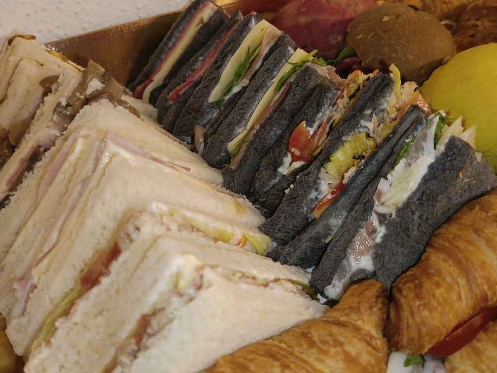Tramezzini de pan blanco y negro junto a cruasanes rellenos